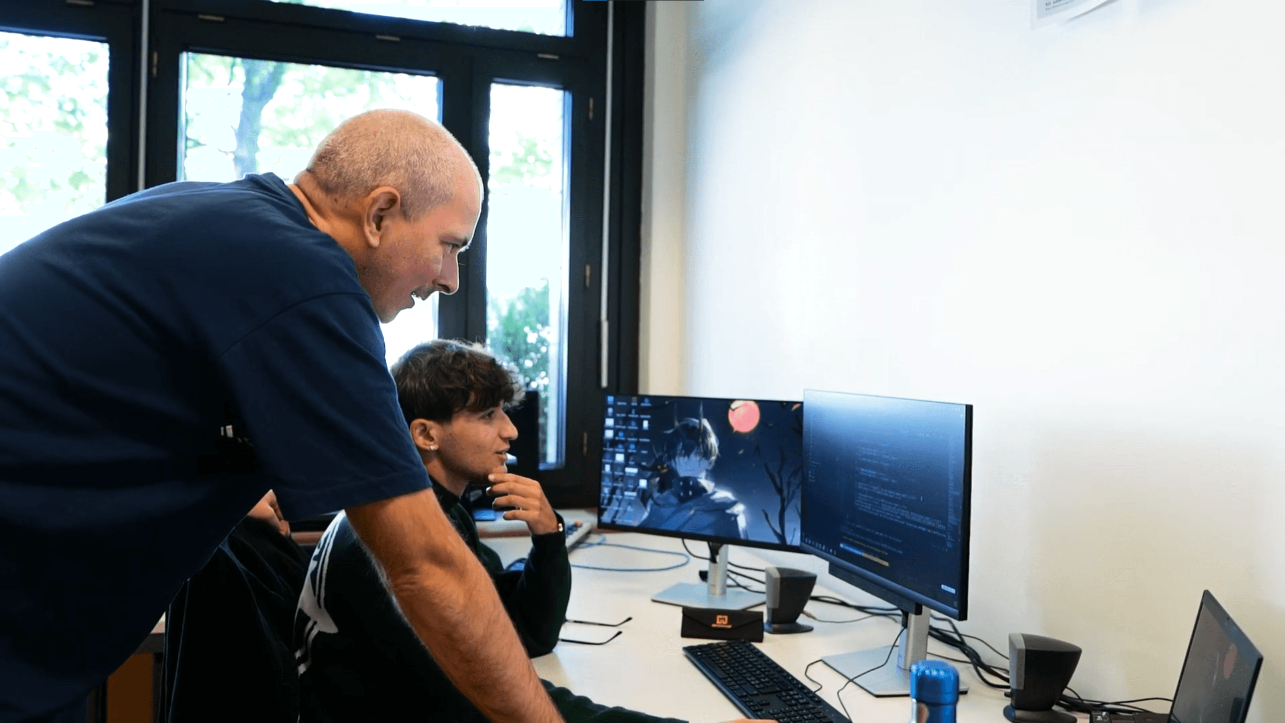 Un formateur Chearn accompagne un apprenant devant son ordinateur